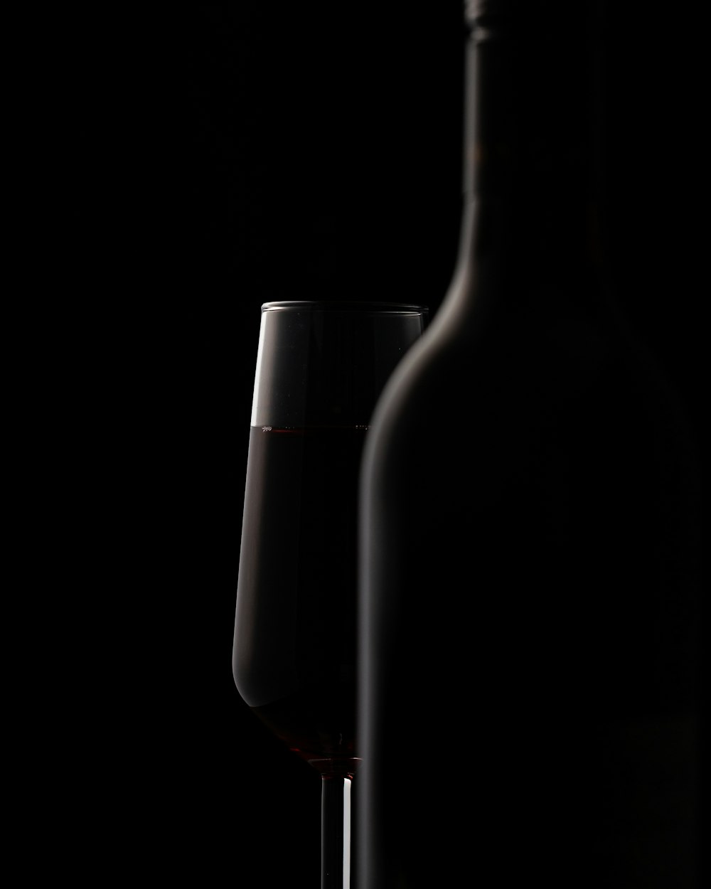 Weinglas hinter der Flasche