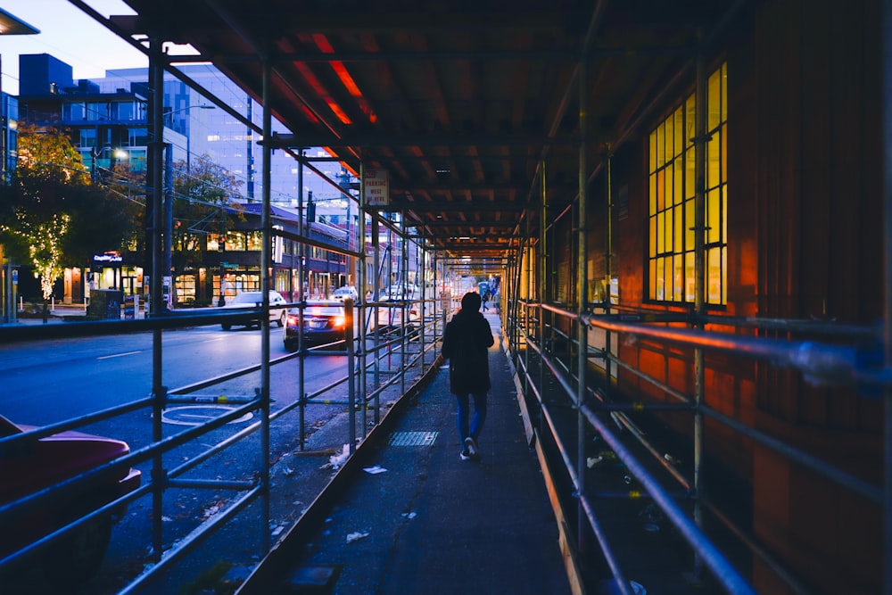 a person walking down a sidewalk next to a building