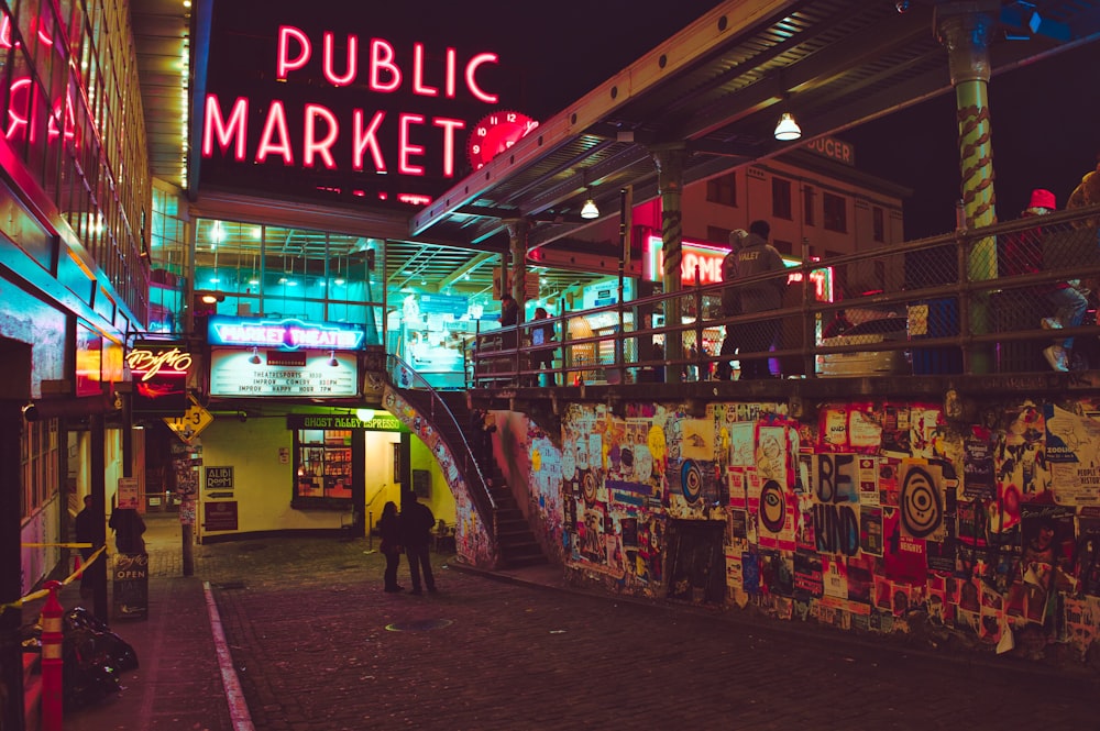 um mercado público com placas de néon e pessoas