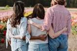 three women holding hand in front of flower garden