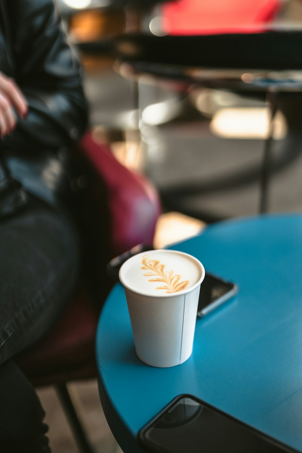 cappuccino in disposable cap on the table