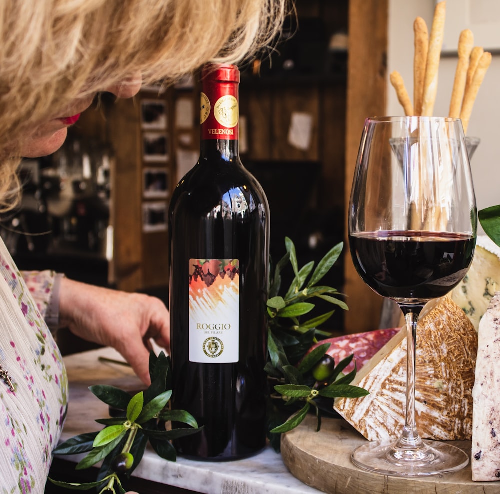 Persona sosteniendo una botella de vino