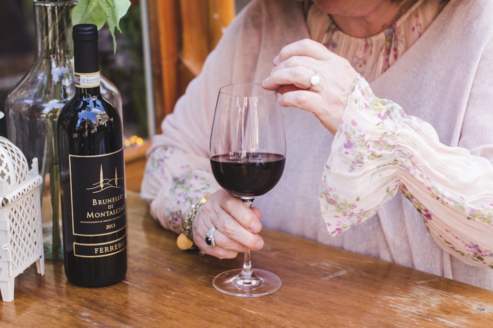 woman holding a glass of wine on the table