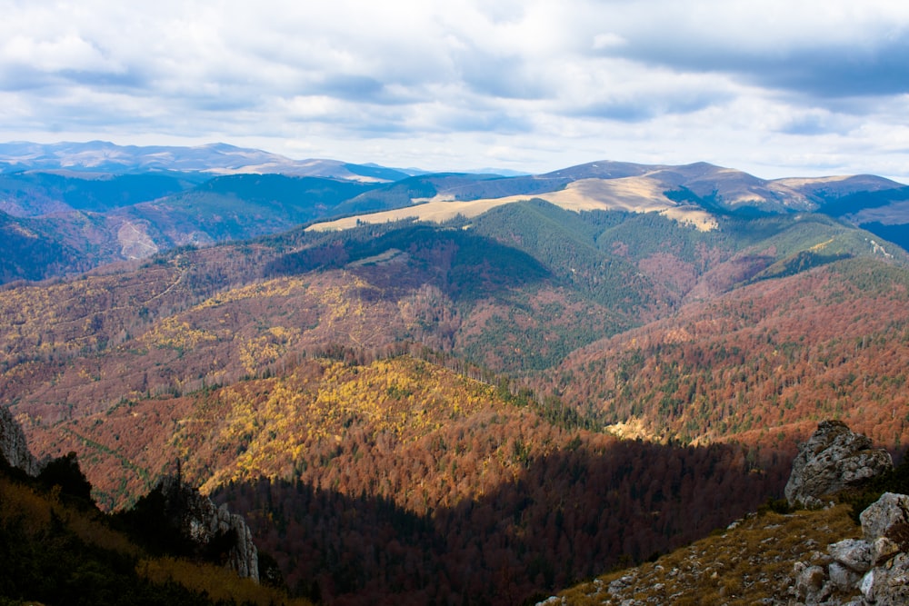 green and brown mountains under white clouds and blue sky during daytime