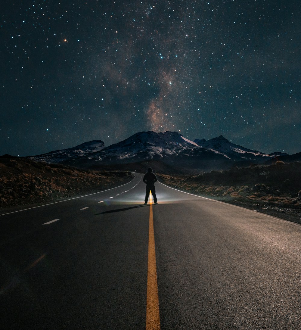 Persona parada en la carretera durante la noche