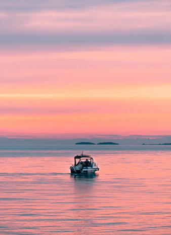A couple enjoying a sunset boat ride on calm blue waters.