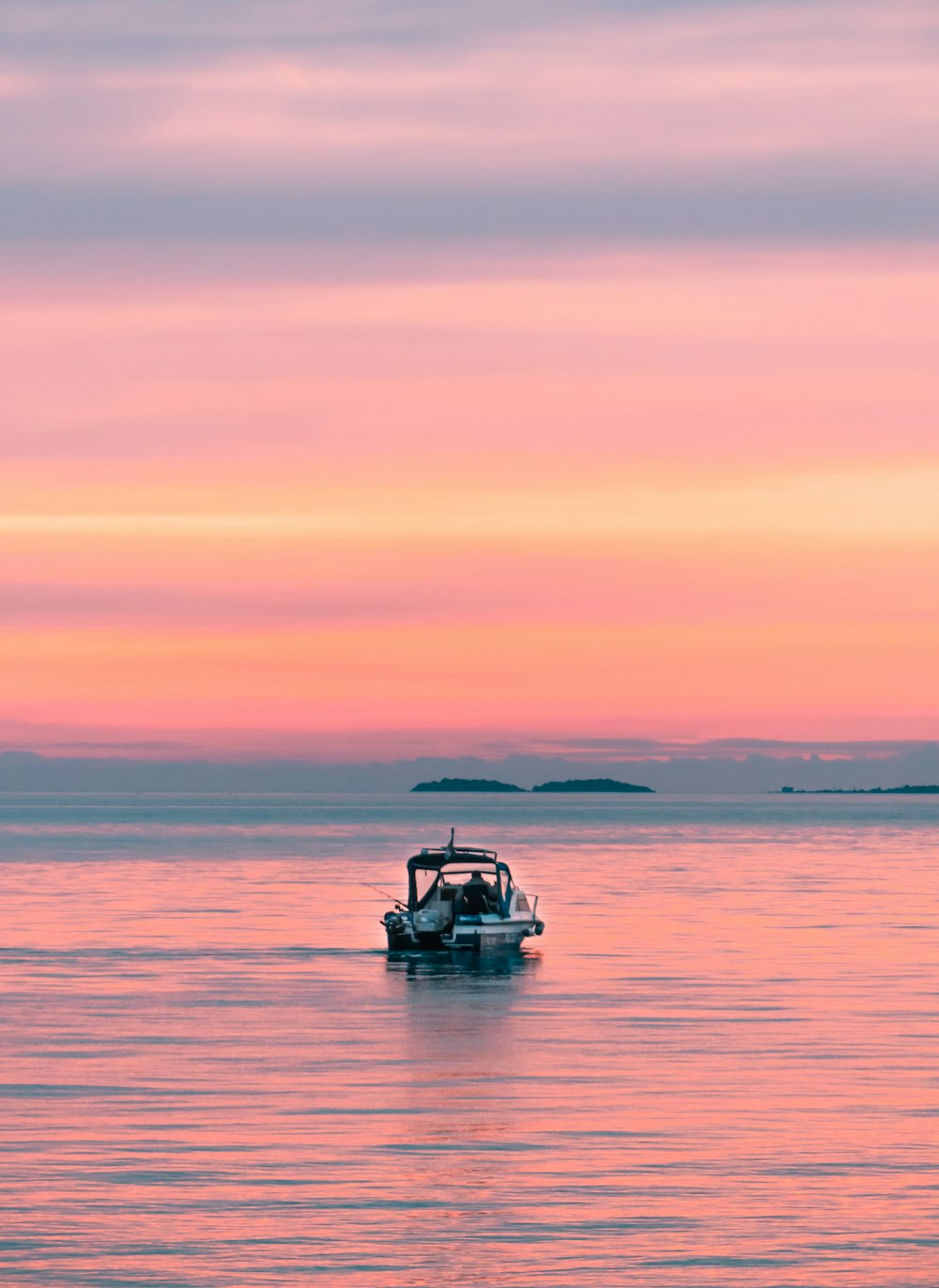 white and black watercraft on body of water during golden hour