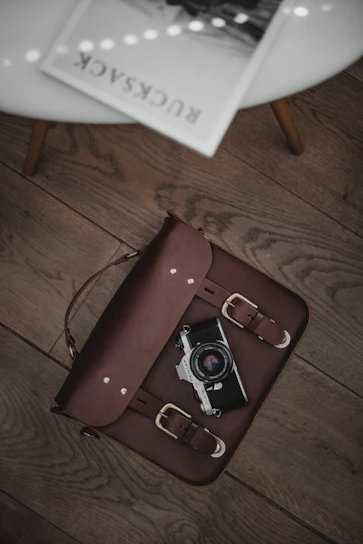 A sleek sureshot camera resting on a wooden table beside a vintage photo album.
