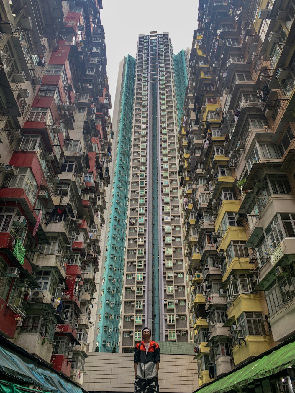 man standing in between of high-rise buildings