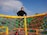A joyful child climbing a colorful playground structure on a sunny day.