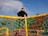 A joyful child climbing a colorful playground structure on a sunny day.