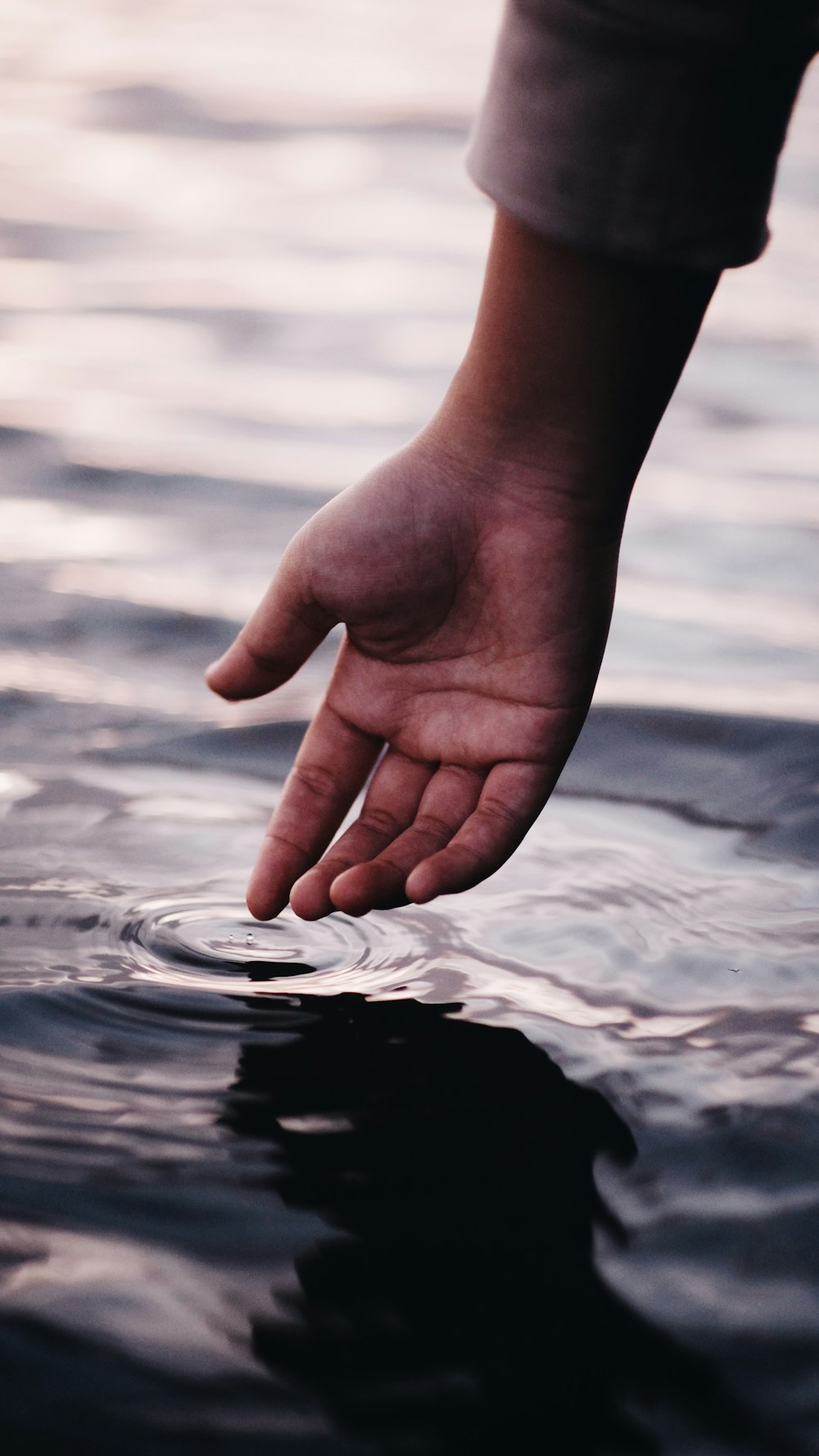 persona tocando el cuerpo de agua