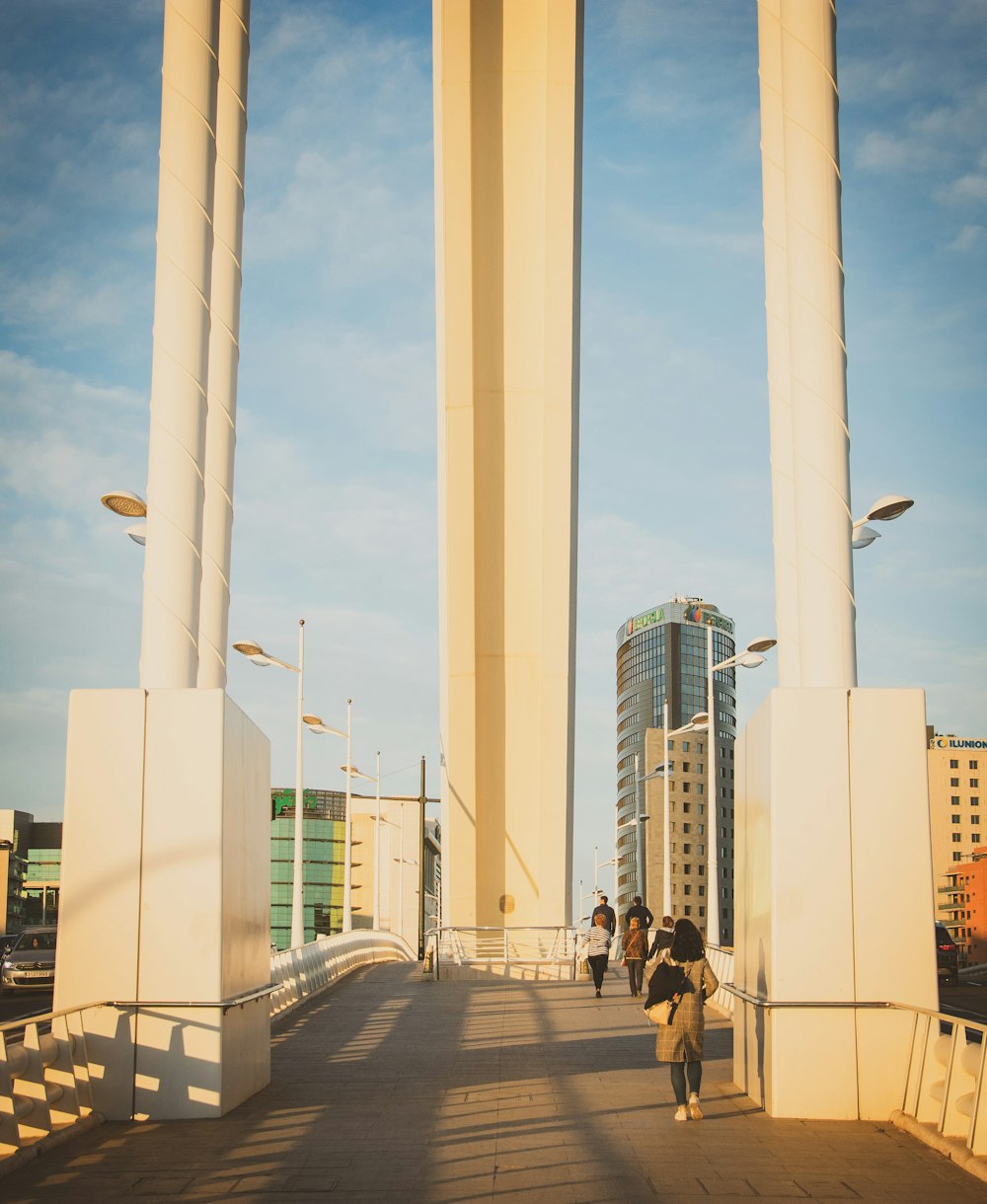 people walking on bridge near buildings during daytime