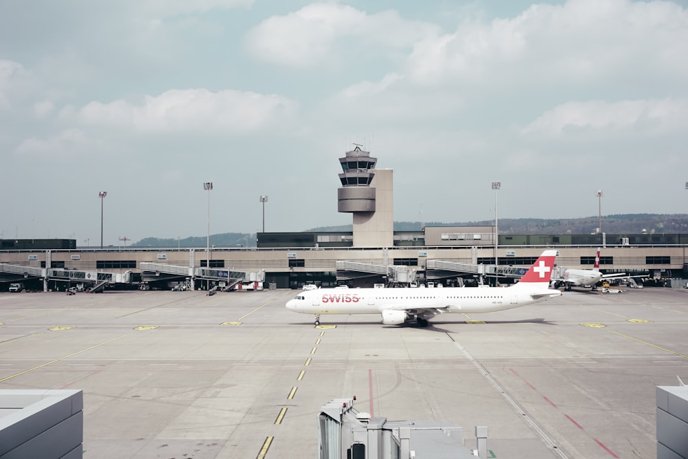 white and red plane landed on airport