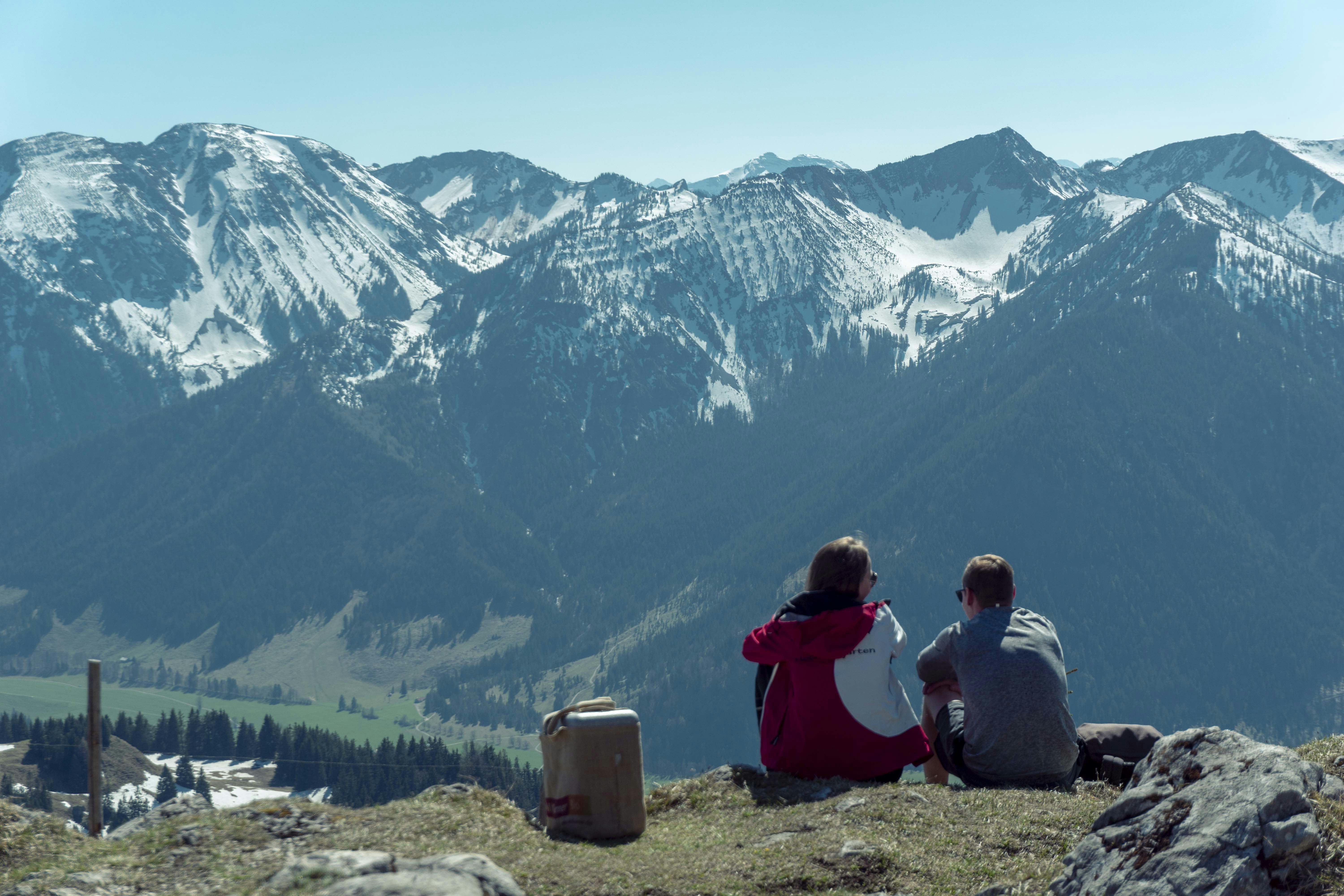 two person sitting outdoors with mountains at distance