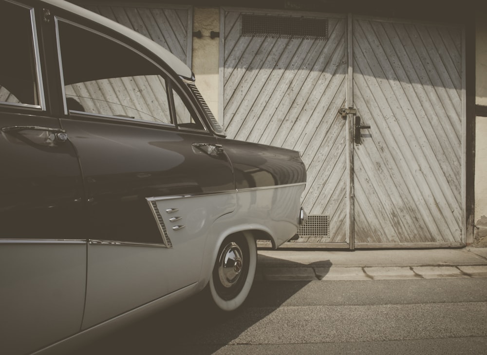 brown and white classic sedan parked in front of building