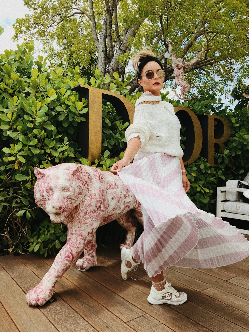 woman standing beside pink animal statue during daytime