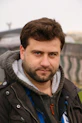 man wearing black hooded jacket standing outdoor during daytime