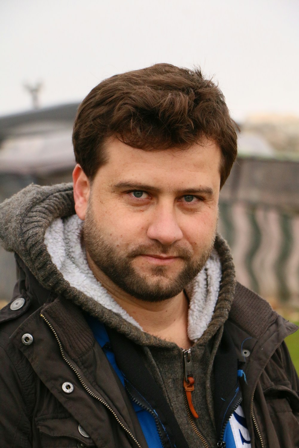 man wearing black hooded jacket standing outdoor during daytime