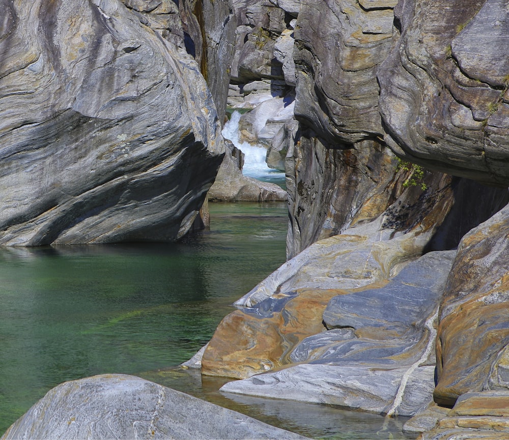 calm body of water near rocks