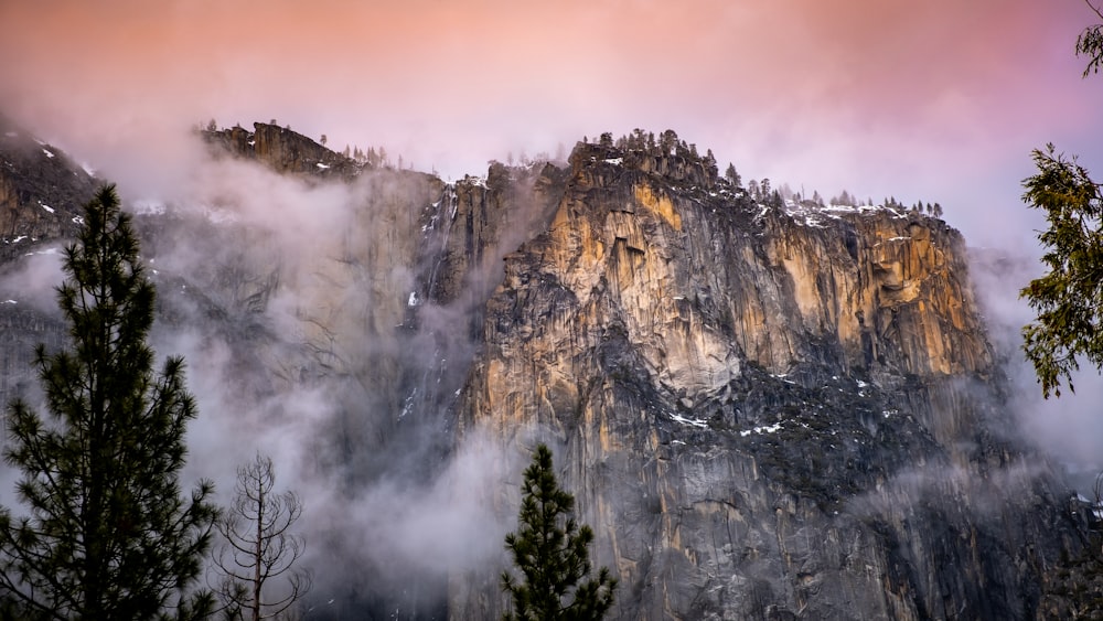 rock hill near mountain covering with fogs