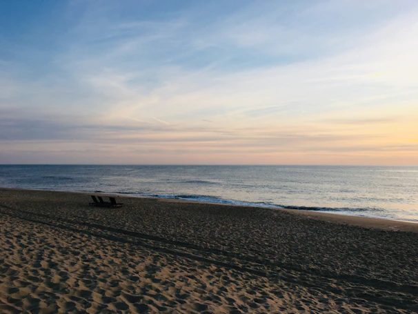 A peaceful beach scene in quiet luxury tones of champagne and taupe, designed for smart TV display.