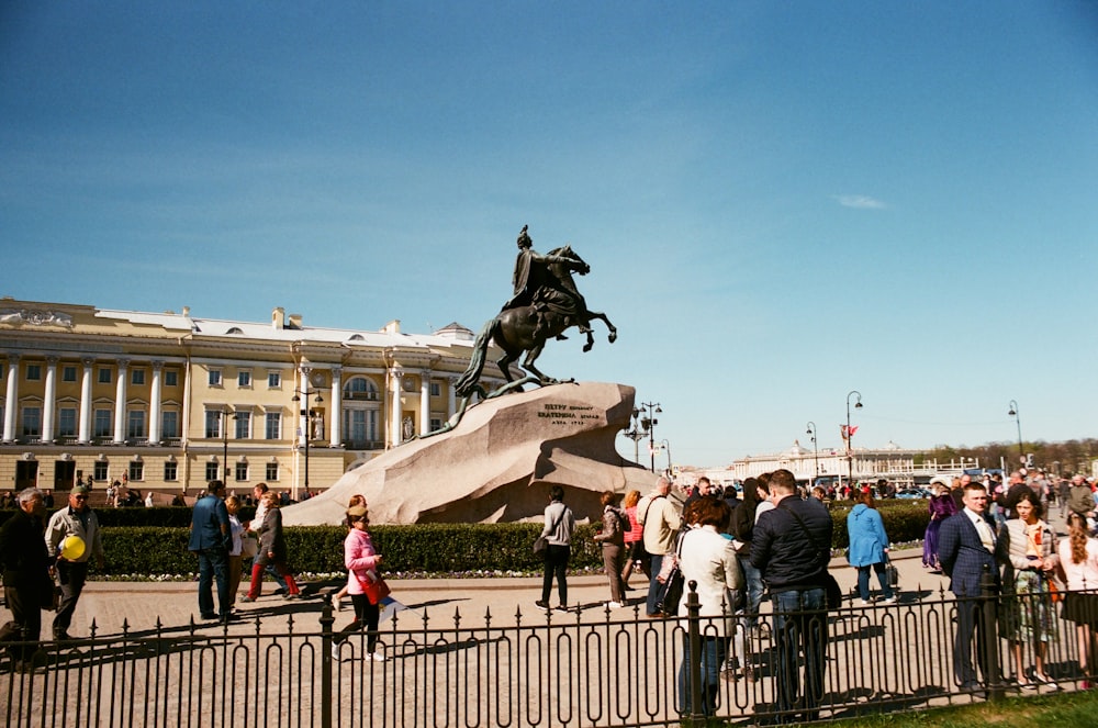 people in park with man on horse statue