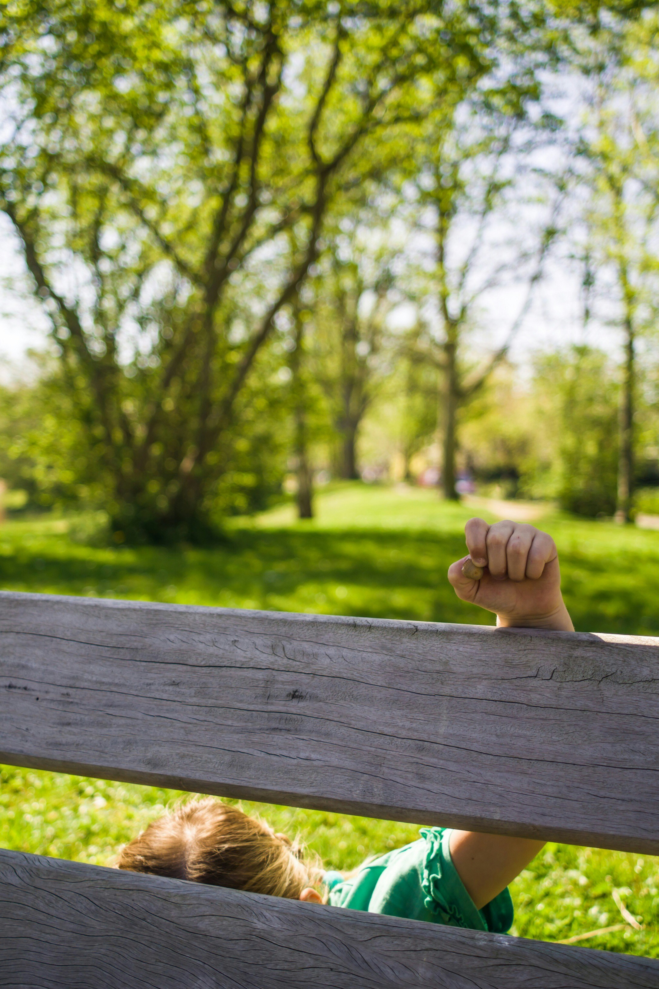 Un jeune garçon assis sur un banc en bois