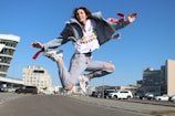 woman wearing blue denim jacket and distressed blue denim jeans jumping during daytime