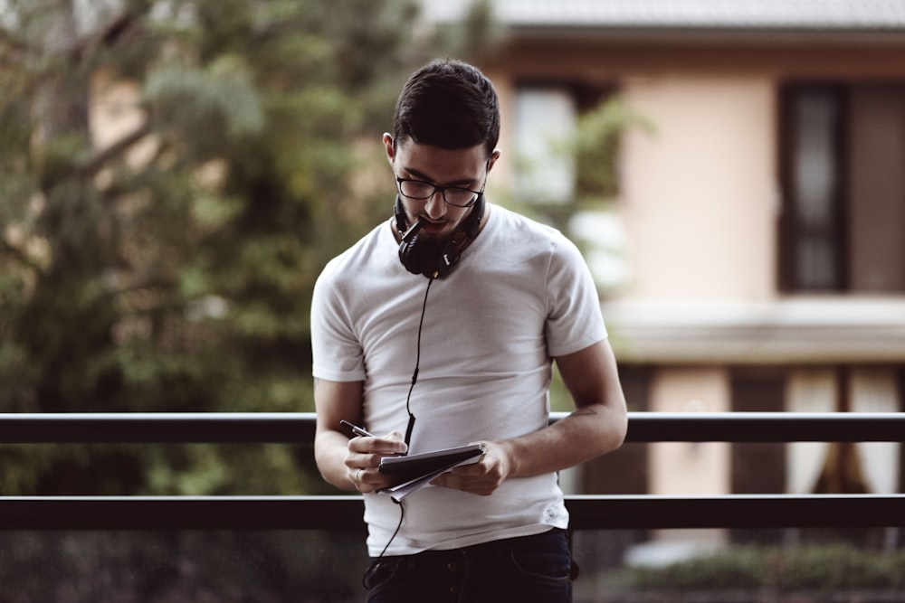 man standing and holding pen and notebook