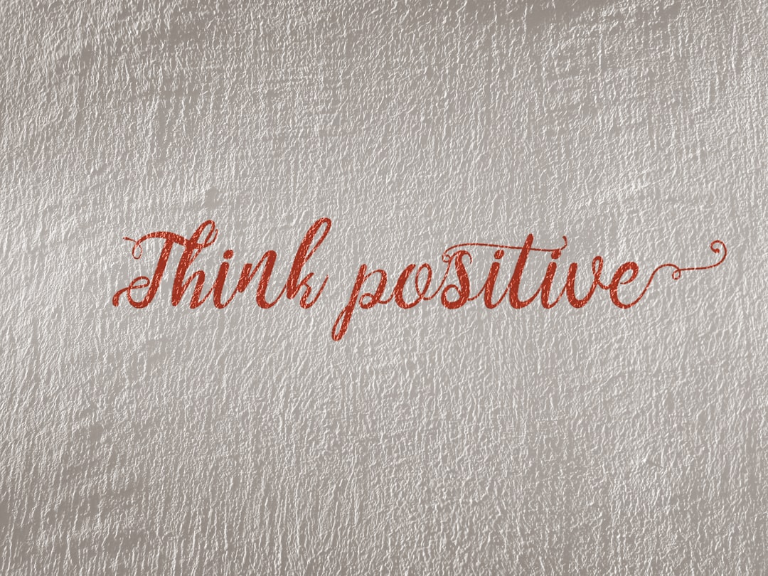 Think positive written in red on parchment background