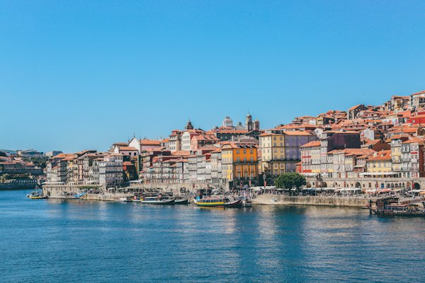 Boats on body of water beside houses — Porto, Portugal