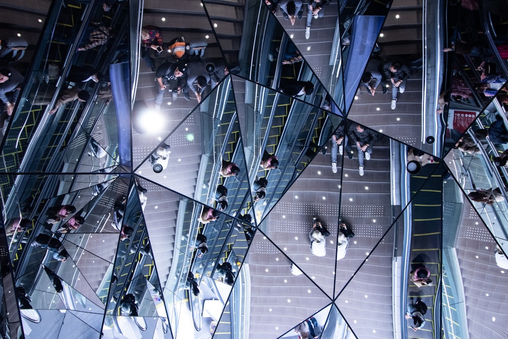 people at the mall reflection on mosaic glass panel