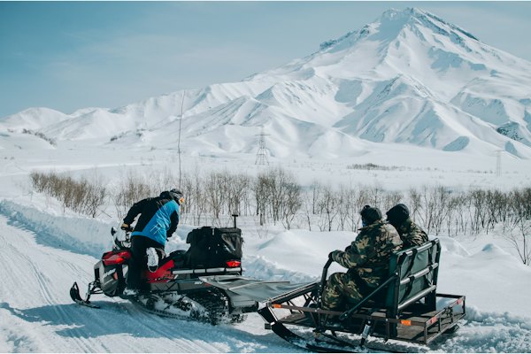 Person riding snow mobile with trailer — Kamchatka, Russia