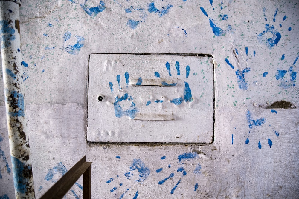 impressão de mão azul na parede de concreto