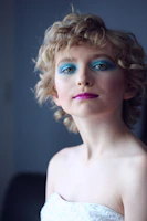woman wearing tube top with green eyeshadow standing