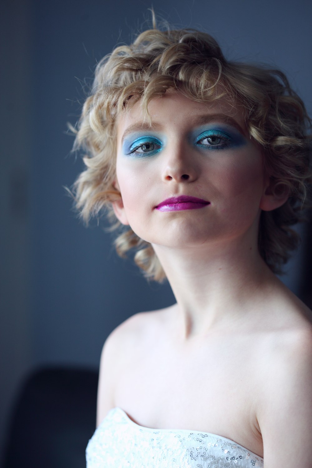 woman wearing tube top with green eyeshadow standing