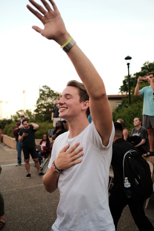 A group celebrating progress together after completing a course, arms raised in joy and connection.