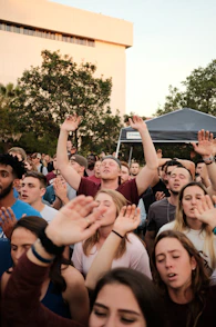 people raising hands during day time