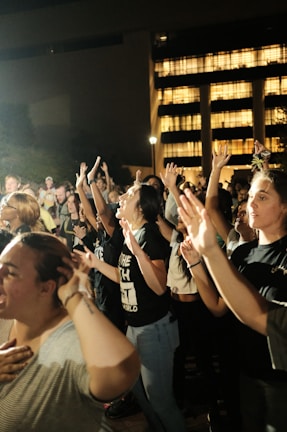 A peaceful moment: community members joining hands in a circle during a unity event at sunset.
