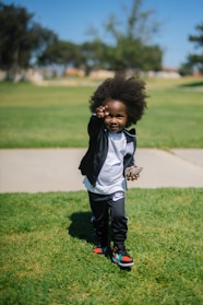 child standing on grass field