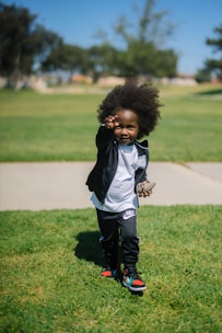 child standing on grass field