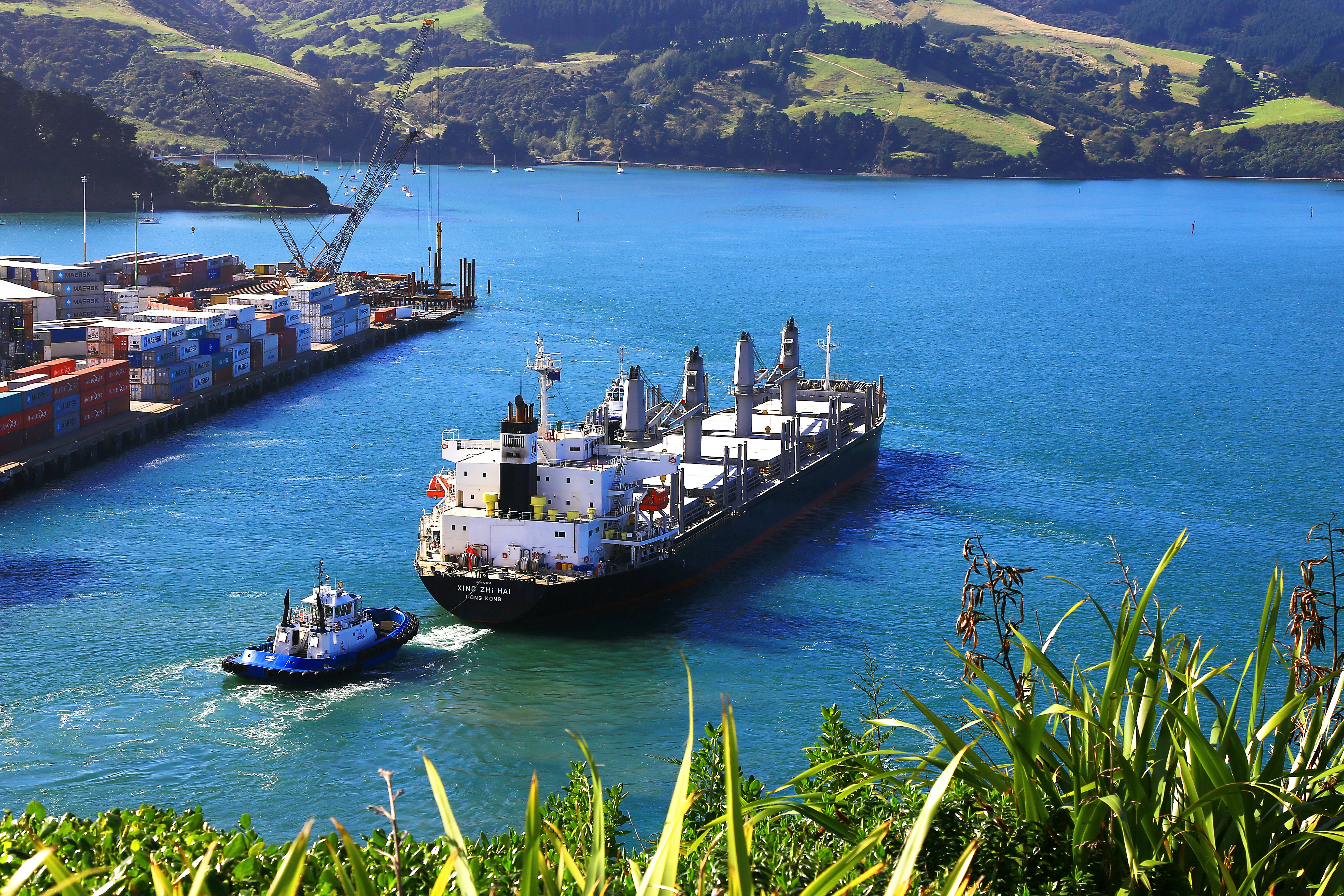 white cargo ship near thug boat