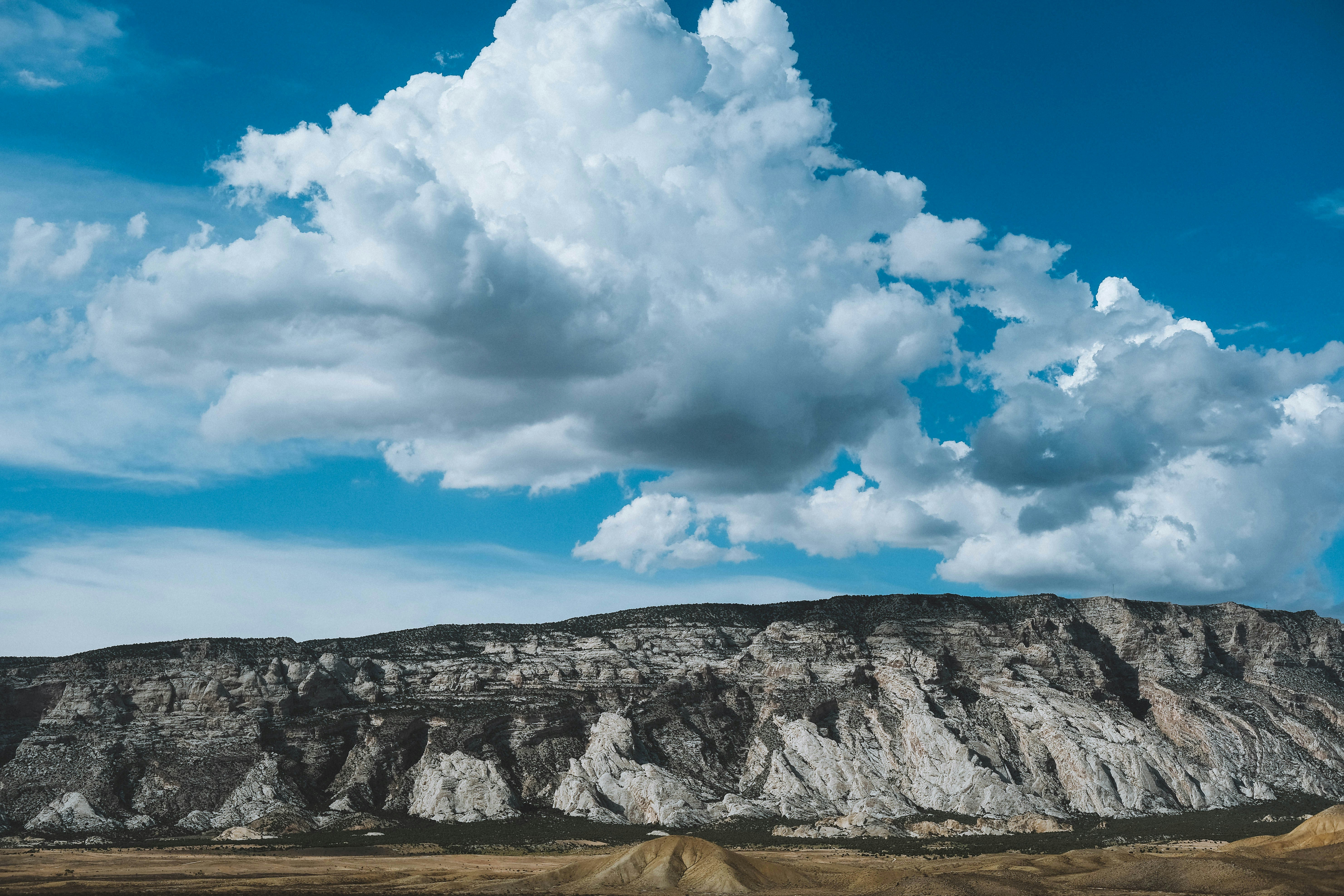 rock cliff under cloudy sky