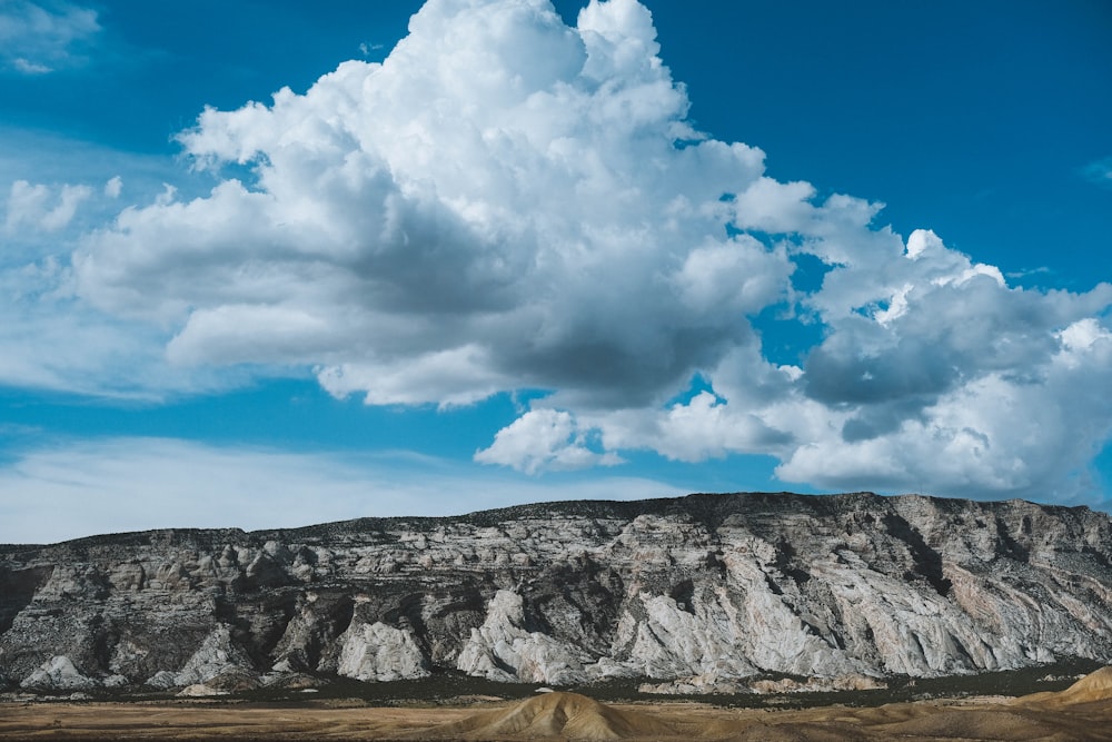 rock cliff under cloudy sky