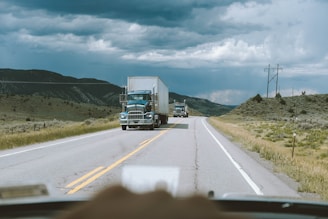 white box truck crossing on road during daytime