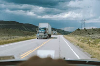 Close-up of a truck driver checking cargo on a busy highway in Brazil.