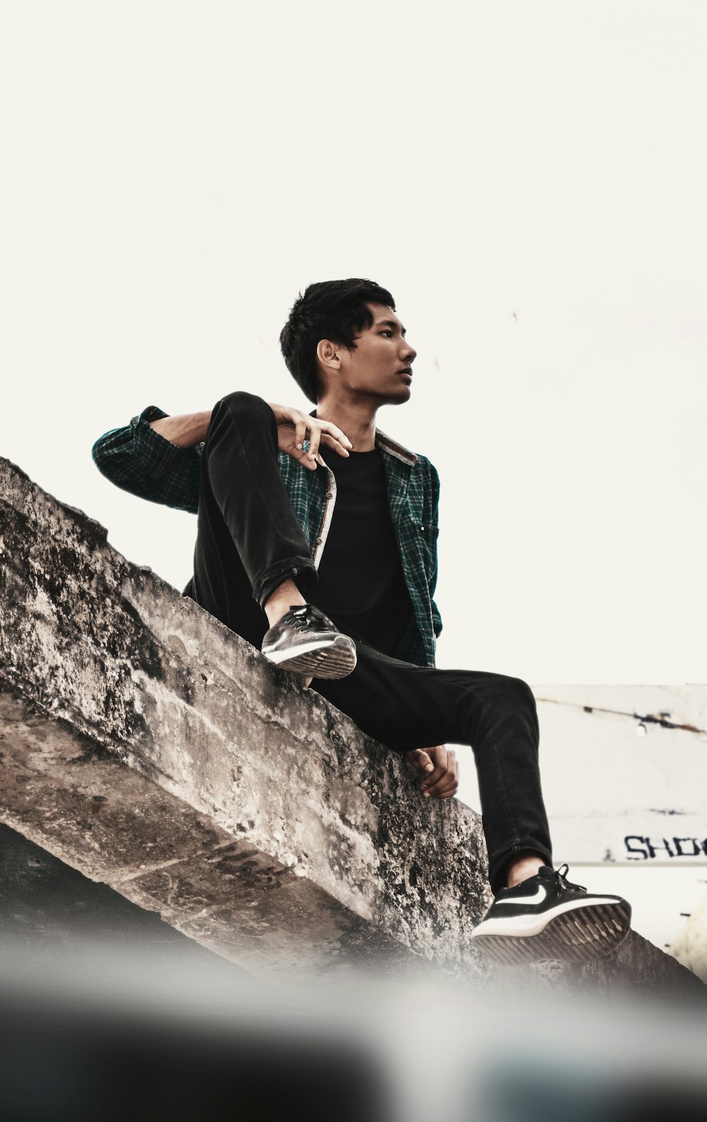 man sitting on concrete pavement