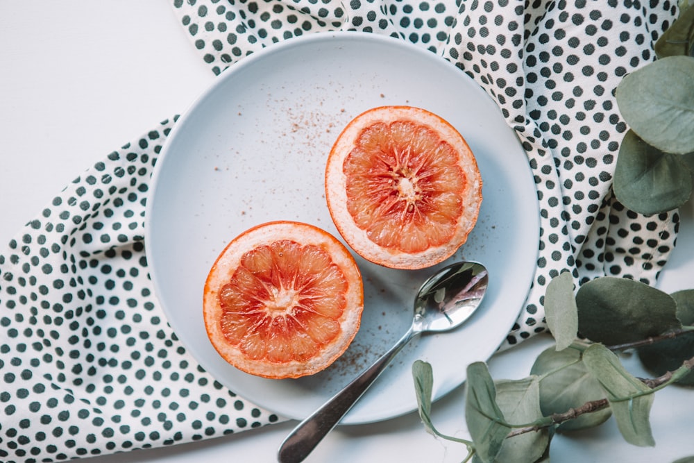 sliced orange on plate near spoon