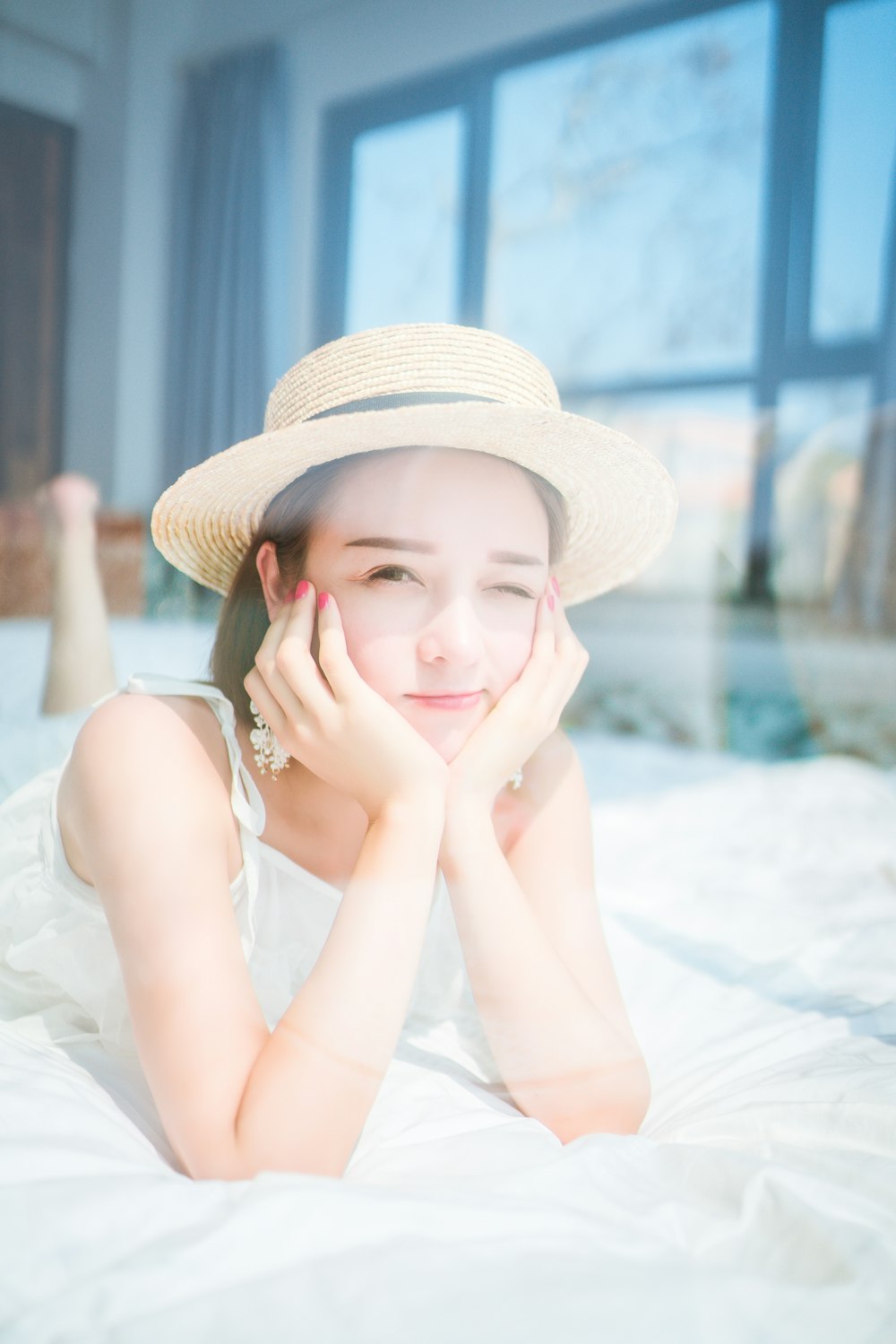 winking woman lying on bed